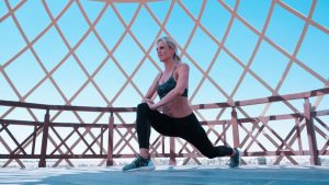 Woman in green sports bra doing lunges